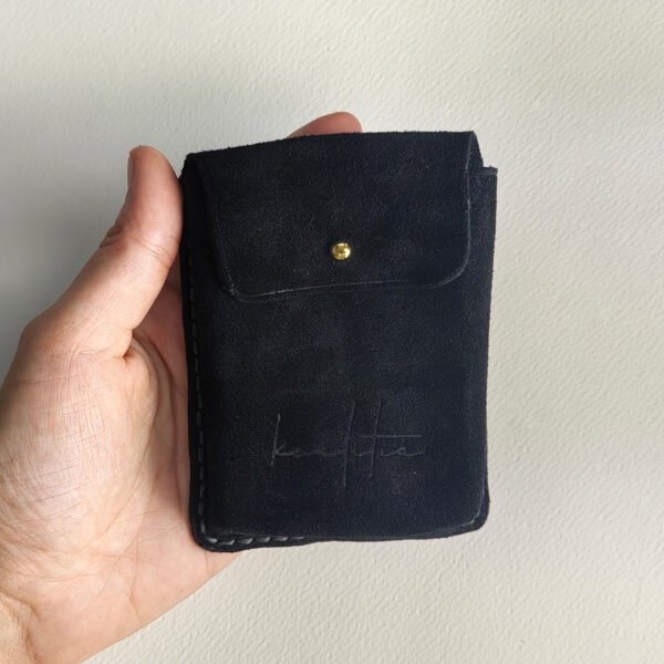 Black velour leather poker deck case, held in hand.