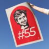 Poster Carlos Sainz, portret desenat digital de mână al pilotului Ferrari, cu semnătura și numărul de cursă #55, ținut în mănă, cu cerul drept fundal.