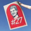 Nico Hulkenberg Print is a digitally hand-drawn portrait of the Haas F1 driver, featuring his signature and #27 racing number, held in hand with the sky as a background.